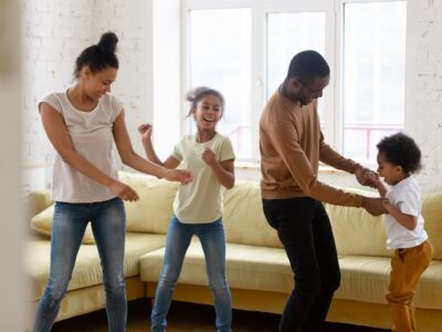 Happy,African,American,Mother,And,Father,With,Two,Children,Dancing.